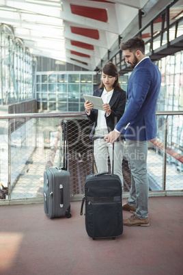 Executives discussing over digital tablet on platform