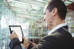 Smiling business executive using digital tablet on platform