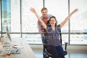 Playful man pushing his colleague on office chair