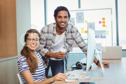 Male and female graphic designers working in conference room