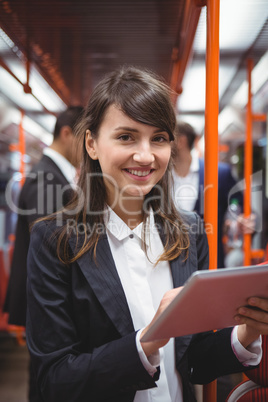 Smiling executive using digital tablet in train