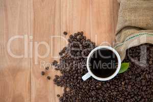 Coffee cup with coffee beans and coffee leaf