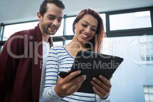 Man and woman discussing over digital tablet