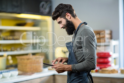 Salesman using digital tablet at counter