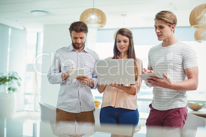Attentive business executives using digital tablet and laptop Attentive business executives using digital tablet and laptop