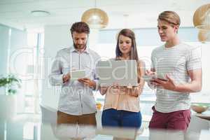 Attentive business executives using digital tablet and laptop
