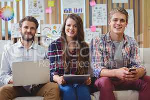 Portrait of graphic designers using mobile phone, laptop and digital tablet