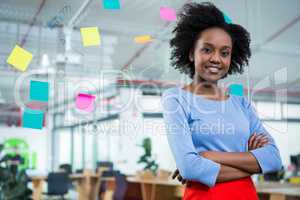 Female graphic designer standing with hands crossed in creative office