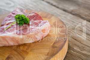 Raw Sirloin chop and corainder leaves on wooden tray against wooden background