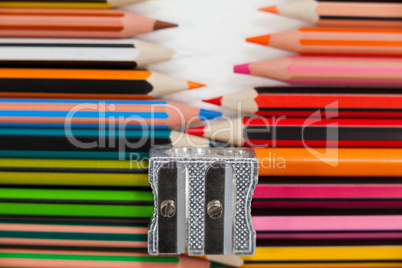 Colored pencils and sharpener on white background