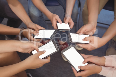 Close-up of students holding mobile phone