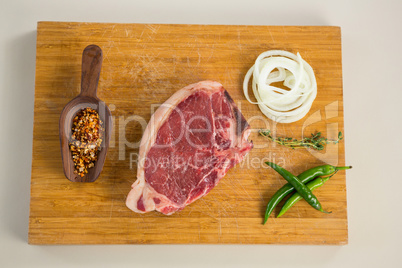 Sirloin chop and ingredients on wooden board