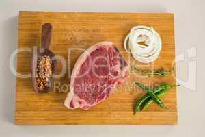 Sirloin chop and ingredients on wooden board