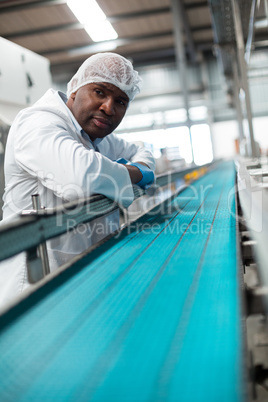 Factory engineer leaning on production line