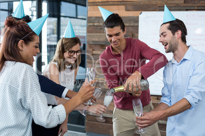 Business executives pouring champagne in glasses