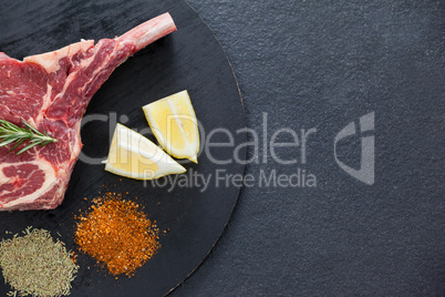 Blade chop, spices and lemon on black round tray