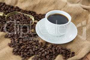 Black coffee, roasted beans and scoop on sack