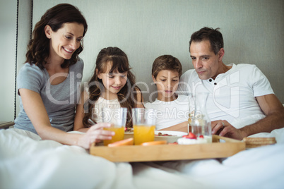 Parents and kids having breakfast in bed
