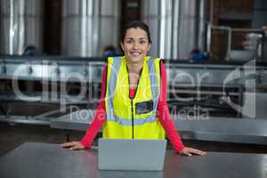 Portrait of factory worker standing in drinks production factory