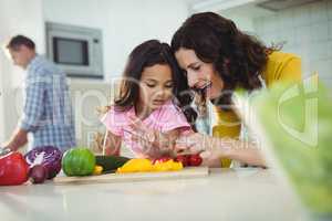 Mother and daughter preparing salad in kitchen