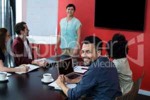 Business executives discussing over flip chart during meeting