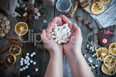 Two female hands holding a bunch of white marshmallow on the tab