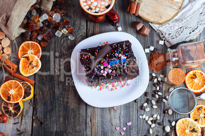 Chocolate cake with colorful sugar sprinkles on a white plate