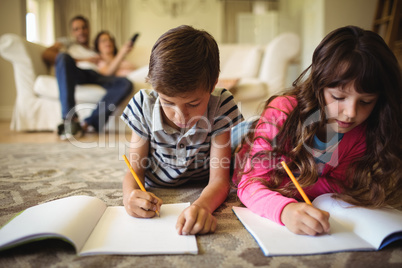 Kids homework while lying on rug