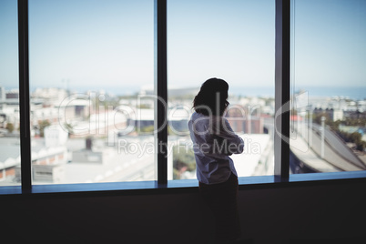 Female business executive looking through window