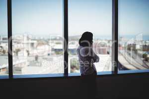 Female business executive looking through window