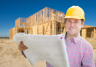 Smiling Contractor Wearing Hardhat Holding Blueprints at Home Co