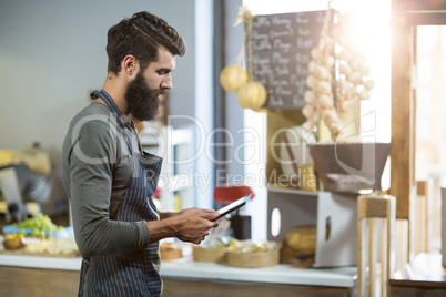 Salesman using digital tablet at counter