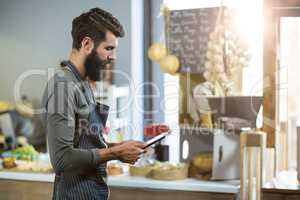 Salesman using digital tablet at counter