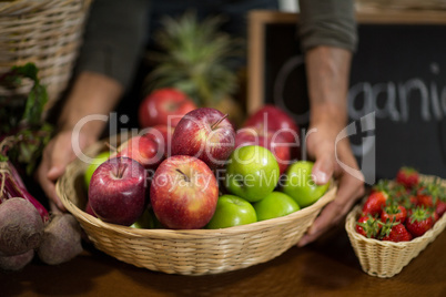 Vendor holding a basket of apples at the grocery store