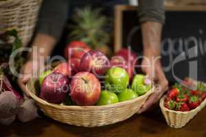 Vendor holding a basket of apples at the grocery store