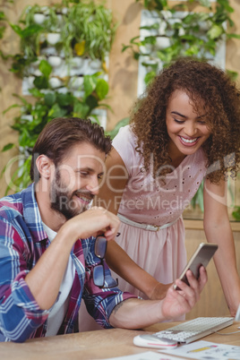 Executives at desk using mobile phone