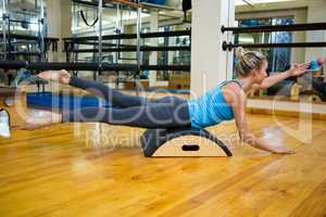 Determined woman exercising on arc barrel