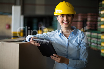 Female factory worker standing with digital tablet in factory