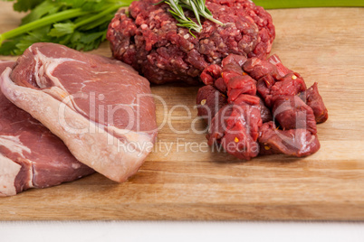 Sirloin chop, beef patty and diced beef on wooden board