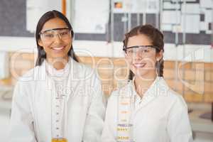 Portrait of smiling schoolgirls standing in laboratory