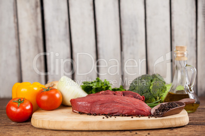 Beef steak on wooden board with ingredients