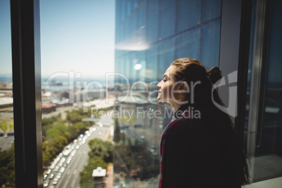 Female graphic designer looking through window