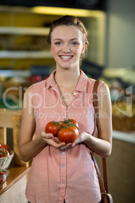 Woman holding tomatoes in grocery store