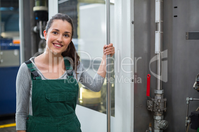 Female factory worker standing at drinks production factory