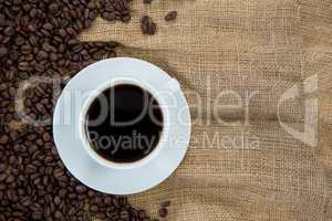 Coffee cup with coffee beans on sack