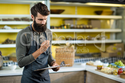 Salesman holding clipboard at counter