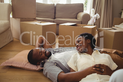 Portrait of smiling couple lying in living room