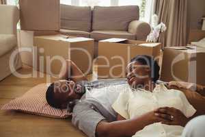 Portrait of smiling couple lying in living room