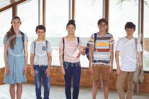 Portrait of happy students standing in corridor