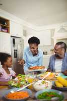 Happy woman serving food to the family